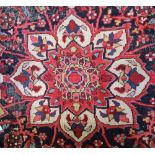 An antique Tabriz carpet with a lobed medallion and all over floral design on a red ground,