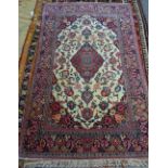 A Kashan rug, Persian, the ivory field with a madder diamond, matching spandrels, floral sprays,