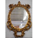 A George III oval wall mirror with pierced swept acanthus and 'C' scroll frame,