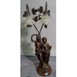 A 20th century faux bronze two branch figural table lamp with frosted floral glass shades,
