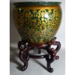 A 20th century ceramic jardiniere with gold foliate decoration on a hardwood stand,