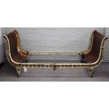 An early 20th century parcel gilt white painted, cast iron scroll end child's bed,