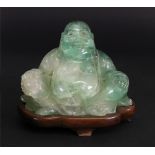 A Chinese carved green quartz figure of a seated Buddha, 20th century, on a carved rosewood stand,