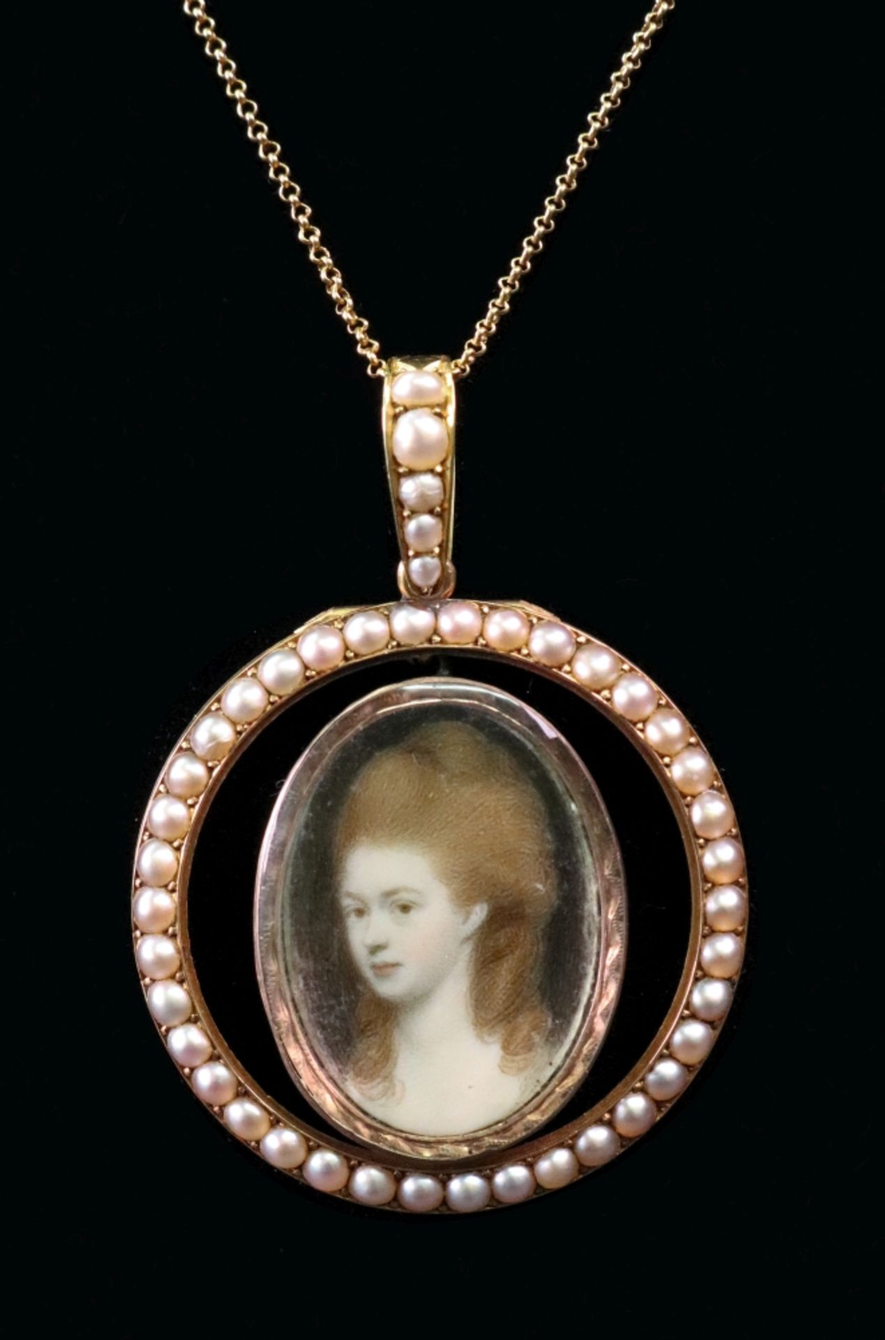 An 18th Century oval portrait miniature of a bust of a lady, in a yellow metal mount,