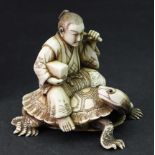 A Japanese ivory okimono of a man, Meiji period, carved seated on the back of a turtle,