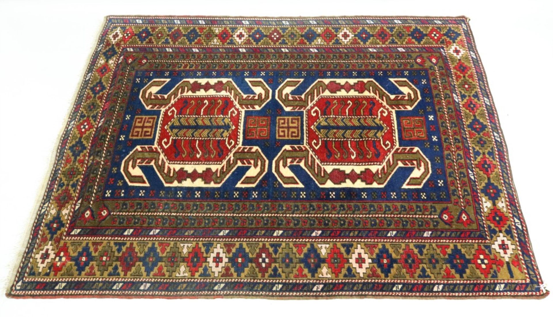 A Taspinar rug, with a blue ground within borders of repeating design, 165 x 123cm.