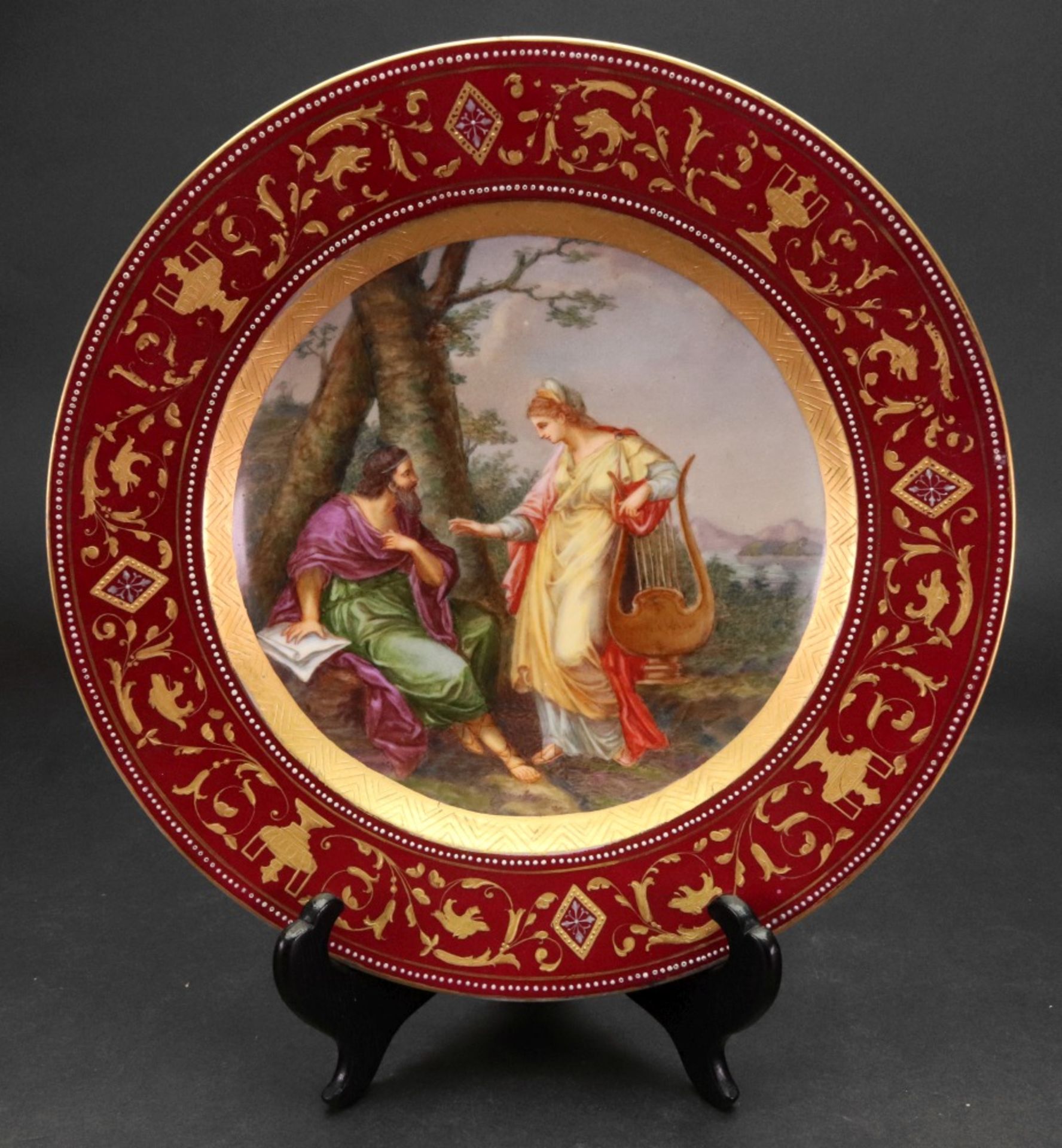 A Vienna style porcelain plate, circa 1900, painted with two classical figures in a landscape,