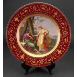 A Vienna style porcelain plate, circa 1900, painted with two classical figures in a landscape,