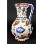 An Iznik pottery jug, early 17th century of pear form, painted in blue, green,