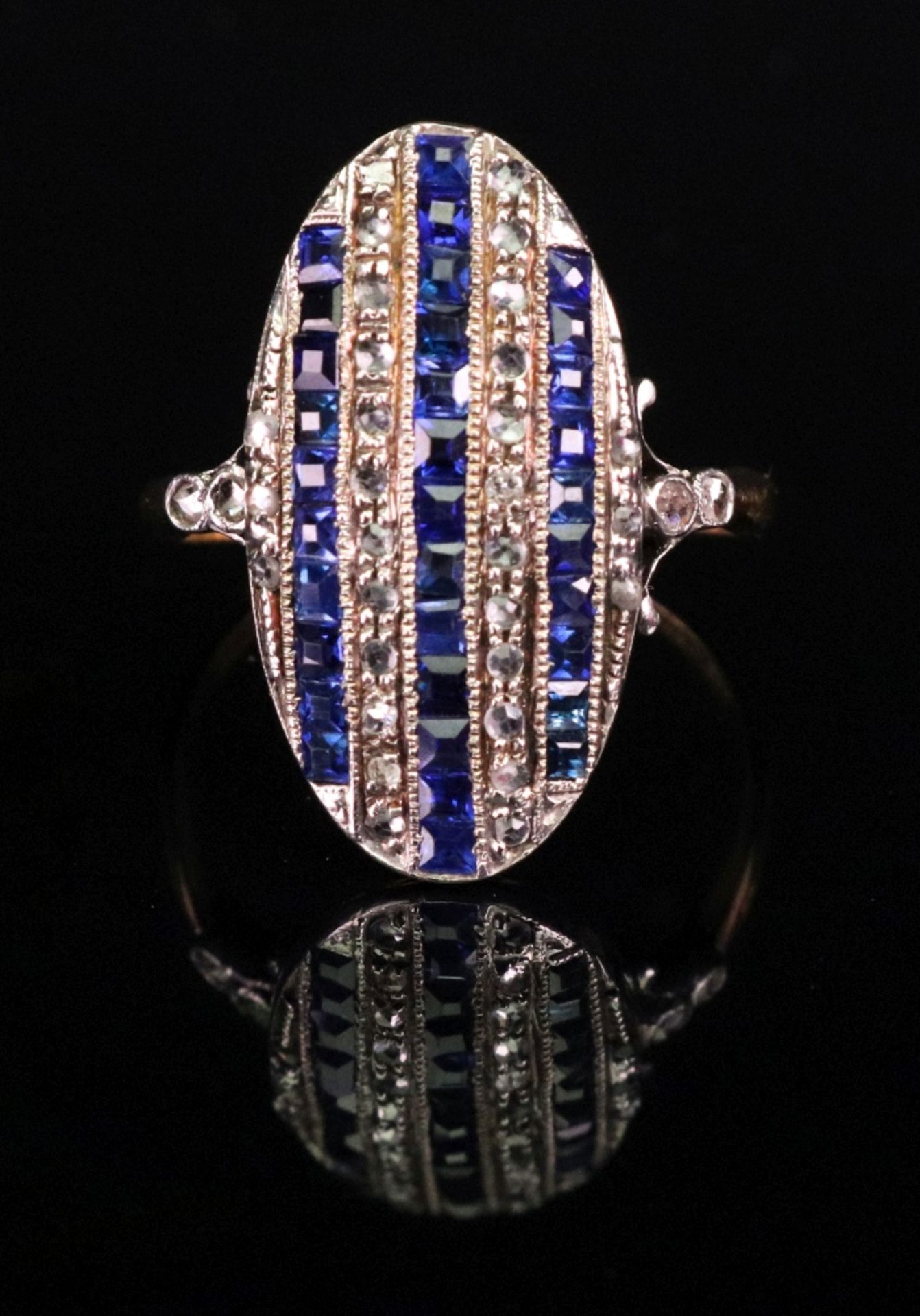 An 18ct sapphire and diamond-set plaque ring of oval design,