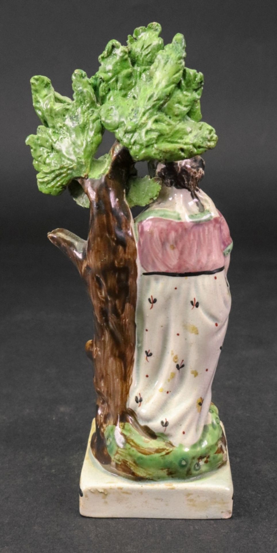 A Staffordshire pearlware figure of a girl, circa 1800, modelled standing against a tree, - Image 2 of 3