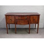 A George III inlaid mahogany sideboard, the serpentine top over a pair of central drawers,