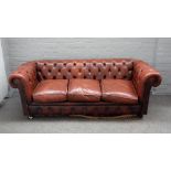 A 20th century button back brown leather upholstered Chesterfield sofa, on turned feet,