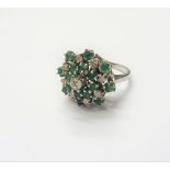 A white gold, diamond and emerald cluster ring,
