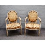 A pair of grey painted Louis XVI style open armchairs with serpentine seats on fluted supports,