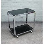 A 20th century smoked glass and chrome rectangular two tier drinks trolley on castors,