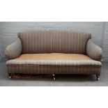 An early 20th century Howard style sofa with shaped arms and sides on tapering square walnut