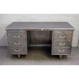 A polished steel office desk of industrial design, with six pedestal drawers,