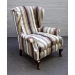A George II style wingback armchair in striped upholstery on squat mahogany cabriole supports,