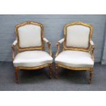 C Chevigny; a pair of Louis XVI gilt framed open armchairs, with serpentine seats,