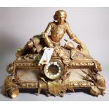 An early 20th century gilt brass mantel clock with finial formed as recumbent knight,