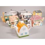 A group of eight 20th century novelty tea pots formed as houses, the largest 16cm high, (8).