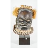 Tribal interest; an African tribal wooden mask decorated all over with cowrie shells,