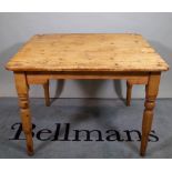 An early 20th century pine kitchen table on turned supports, 102cm wide x 74cm high.