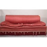 A 20th century hardwood framed red upholstered sofa with gold and red tasseled frieze,