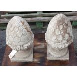 A pair of 20th century reconstituted pine cone finials, on square plinth bases, 54cm high,