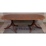 A George III style mahogany 'D' end dining table, with one extra leaf, on outswept supports,