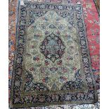 A Turkish silk rug, the madder field with a black and ivory medallion, orange spandrels,