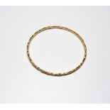 A gold circular bangle, with faceted decoration, weight 9.3 gms.