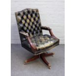 A studded green leather upholstery open arm office swivel chair on four down swept supports,