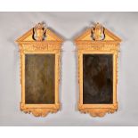 A pair of George II style gilt framed mirrors each with broken architectural cornice,