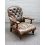 A Victorian mahogany framed open armchair with studded green leather upholstery on turned supports,