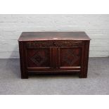 A 17th century oak coffer, with twin plank lid and carved double panel front, 99cm wide x 68cm high.