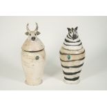 Two Charlotte Cadzow Amalie pottery jars and covers, one depicting a zebra, the other a bull,
