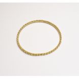 A Middle Eastern gold bangle of circular form, with faceted and ropetwist decoration, weight 16.