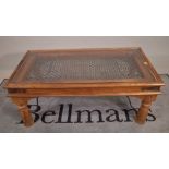 A 20th century hardwood and glass rectangular coffee table on block supports,