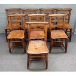 A set of eight early 20th century stained beech chapel chairs on turned supports,