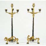 A pair of Regency style gilt and patinated three branch candelabra, converted to table lamps,