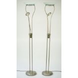 A pair of modern chrome uplighters of tubular form with a mid-tier adjustable reading light and