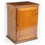 An 18th century inlaid oak hanging spice cupboard, the single door enclosing six drawers,