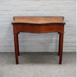 A George III mahogany tea table, the carved serpentine foldover top on turned block supports,
