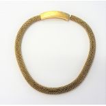 A gold collar necklace, in an interwoven mesh link design, the curved clasp of panel form,