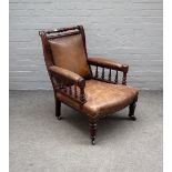 A 19th century mahogany framed leather upholstered easy open armchair with turned supports,