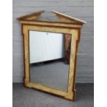 A modern mirror, the broken architectural cornice,