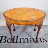 A Victorian style walnut oval centre table on tapering ball and claw supports,