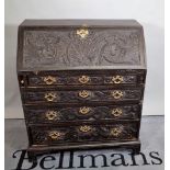 A George III ebonised bureau with four later carved decoration bracket feet, 90cm wide x 107cm high.